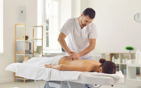 Técnico en masoterapia realizando masaje terapéutico en clínica