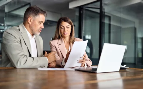 Técnicos jurídicos revisando documentos legales frente a computador.