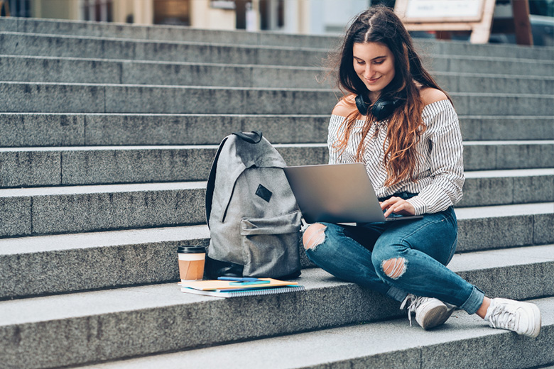 Estudiante buscando información sobre becas en un notebook