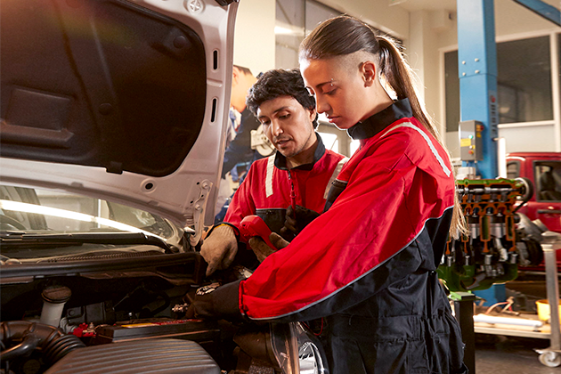 Alumnos de Mecánica Automotriz en AIEP trabajando en la reparación de un motor de vehículo