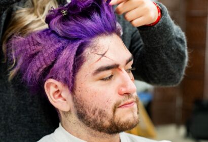 Modelo cosplay siendo maquillado como personaje de ficción.